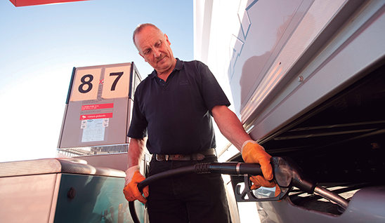 Camionero llenando deposito de camión Camionero llenando deposito de camión